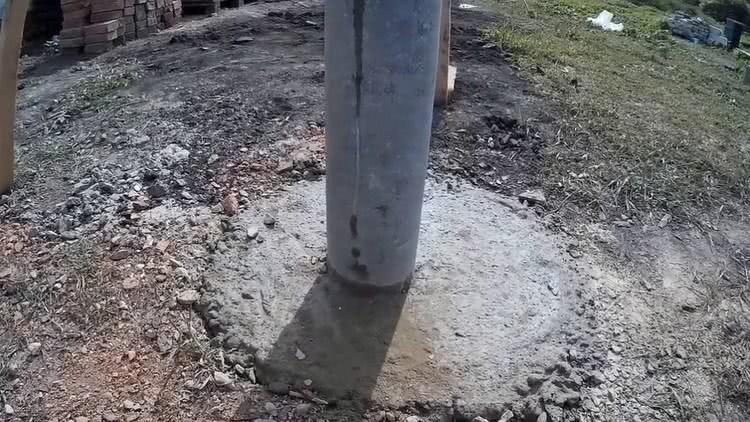 Для надежности опоры следует заливать бетоном, для этого лунка должна быть шире самой трубы